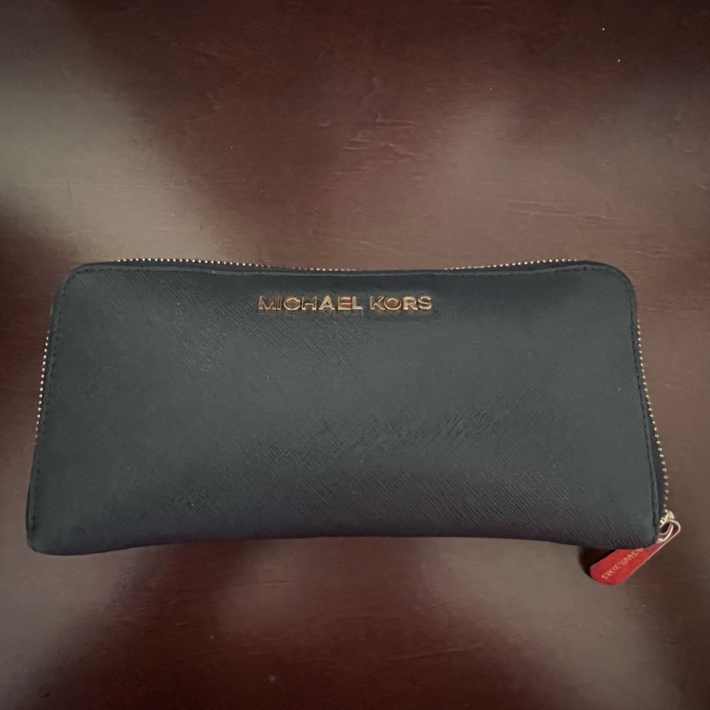 Navy Michael kors wallet with gold hardware and zip closure. Lots of slots